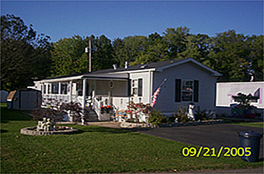 Beautiful mobile home on lot in New Middletown, OH with pleasant landscaping and mature trees